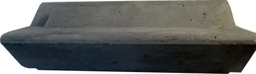 Betonstein mit flacher Oberfläche und schrägem Rand, möglicherweise Teil eines Heizsystems von Wolf. Nutzbar in einer Brennkammerinstallation.